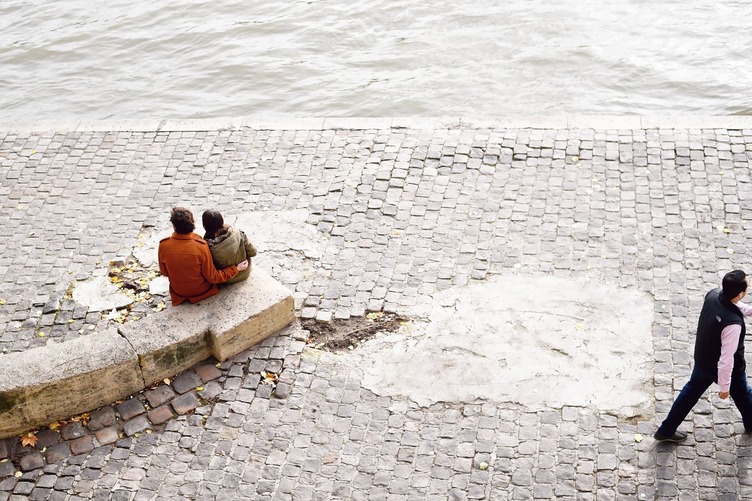Couple sitting on the bank of the Seine in Paris