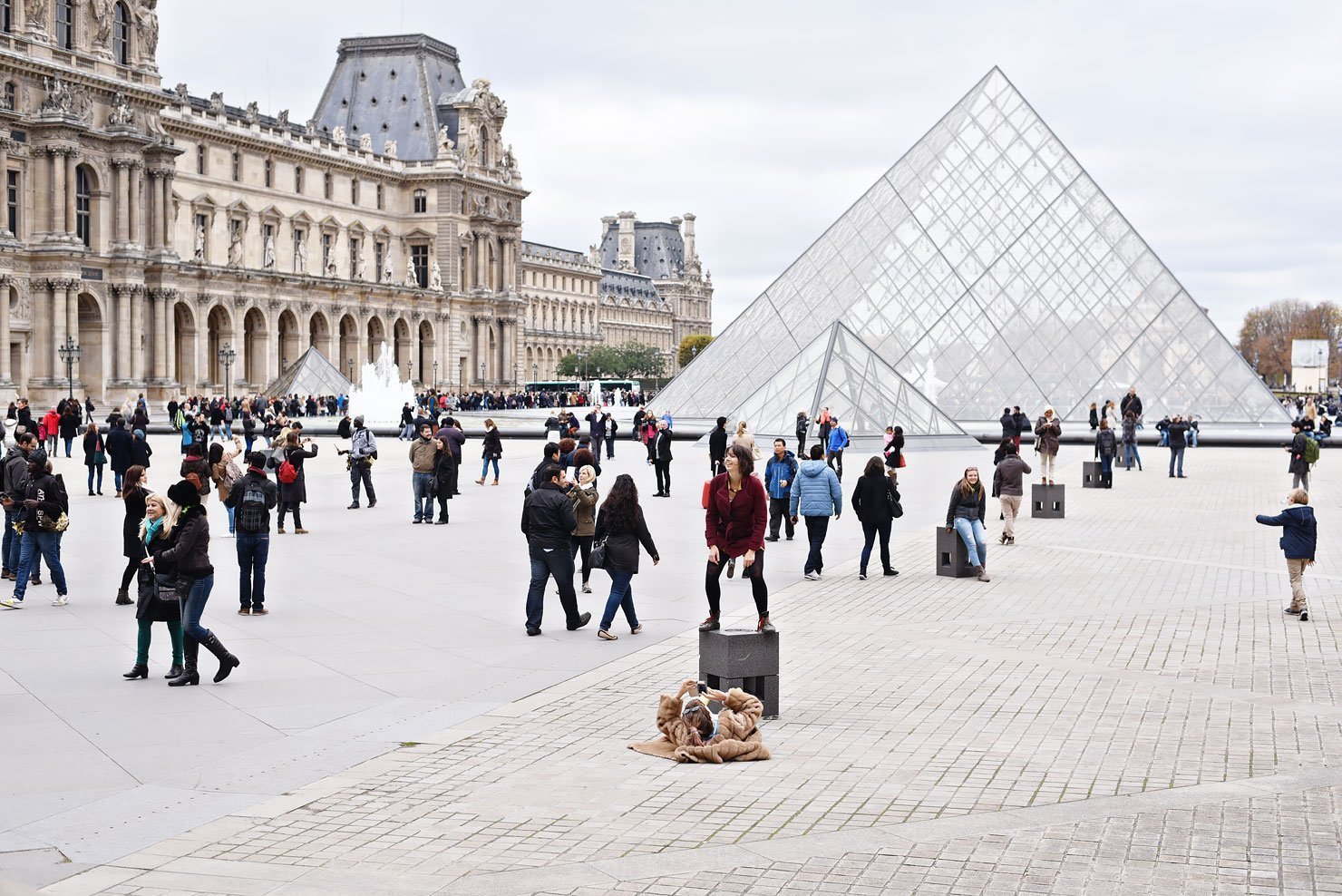 People posing in front of the Louvre in Paris.