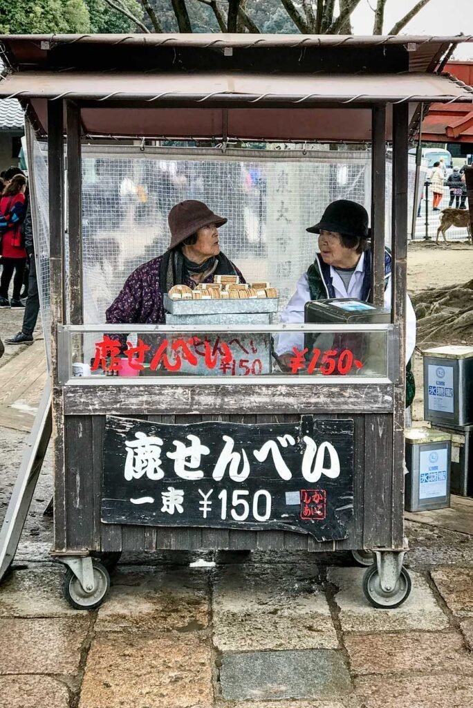 Women selling deer biscuits in Nara Park, Japan. Nara is a great day trip from Kyoto or Osaka