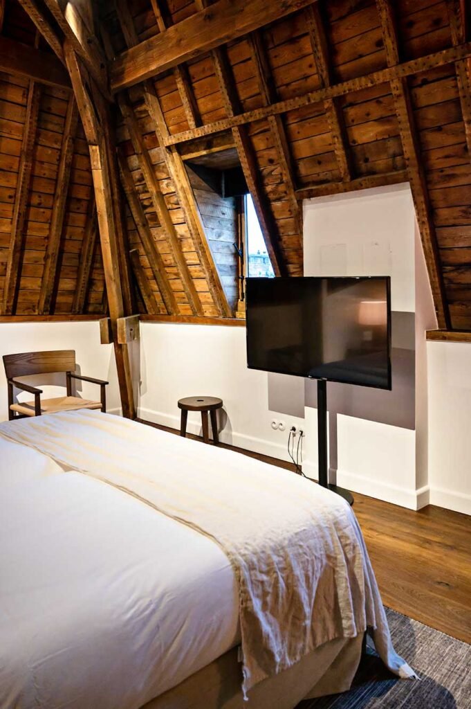 Guest room at August, a design hotel in Antwerp, Belgium with wooden ceilings.
