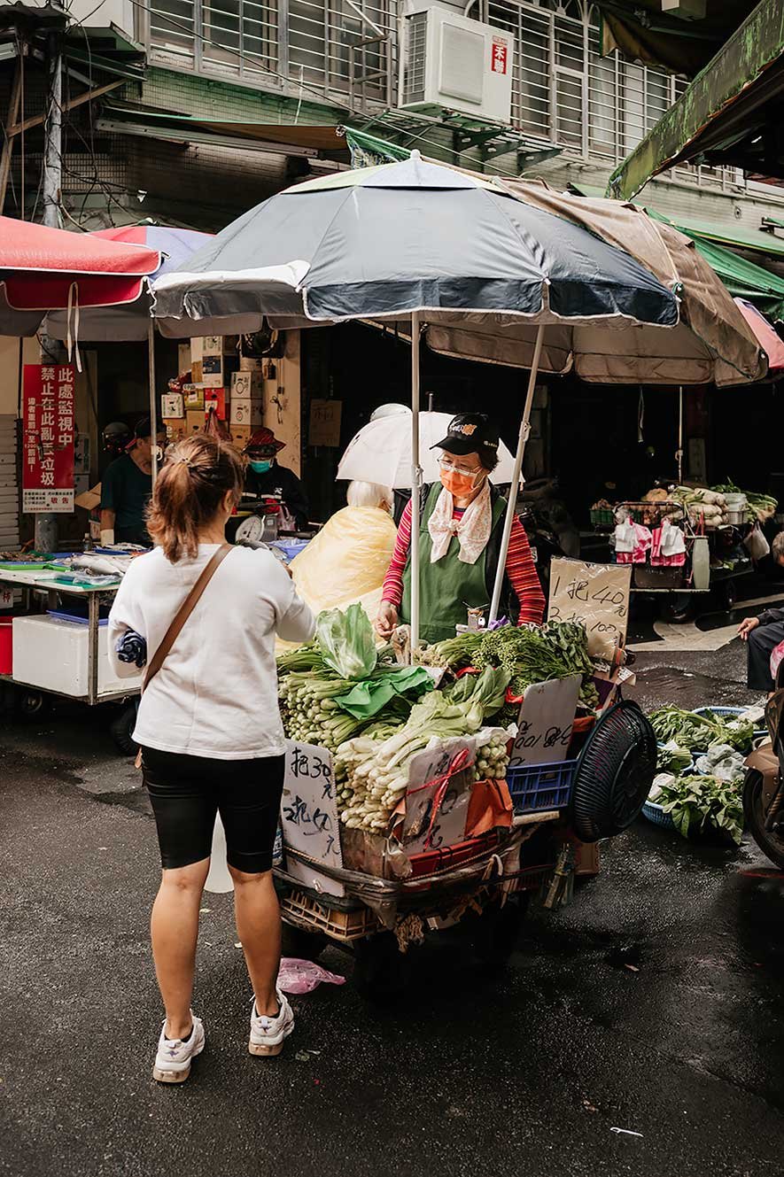 Taipei Eats food tour - vrouw verkoopt groenten op de markt