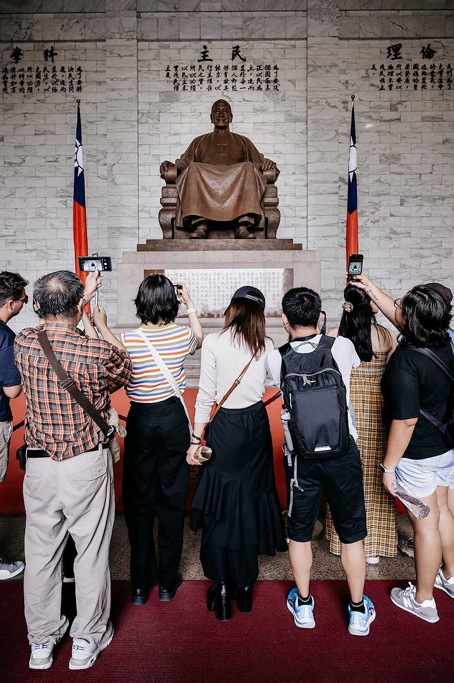 Mensen nemen foto's van het standbeeld van Chiang Kai-shek bij de Memorial Hall in Taipei, Taiwan