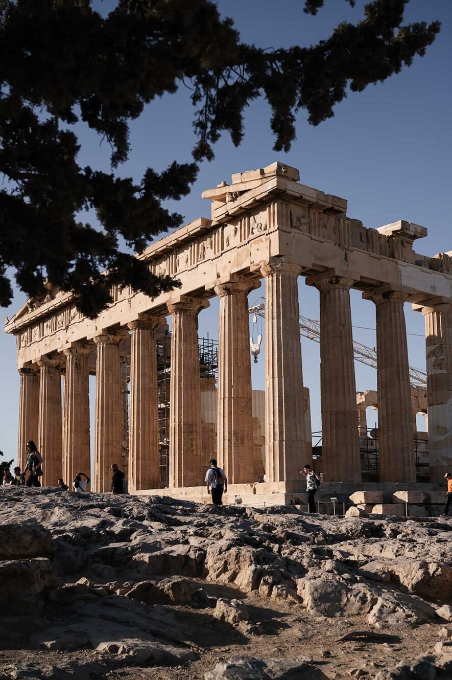 Tourists standing in front of the Parthenon on the Acropolis in Athens in the morning.