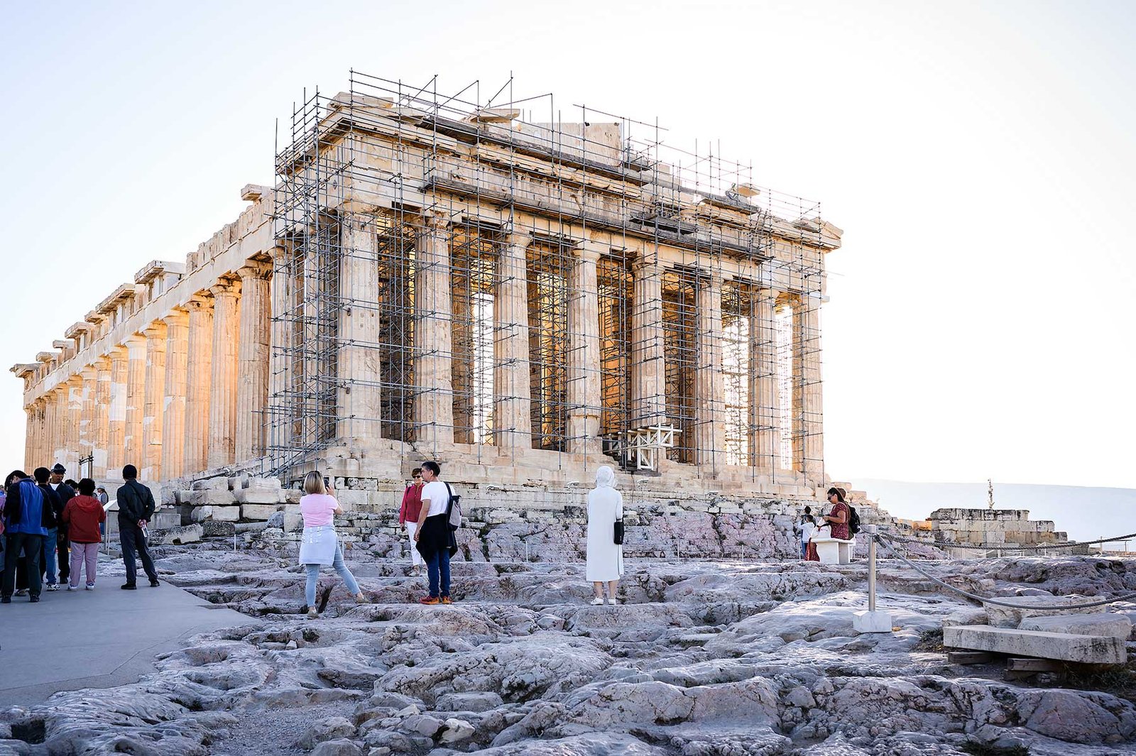 Tourists standing in front of the Parthenon on the Acropolis in Athens in the morning.