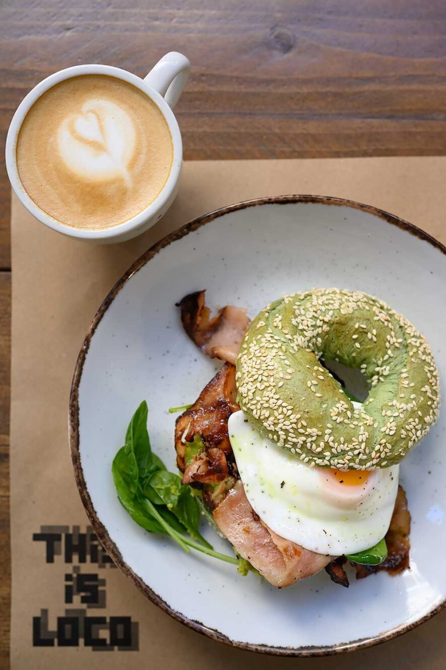 Green bagel with egg and bacon at restaurant This is Loco in Athens